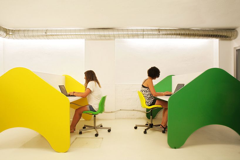 DOS MUJERES SENTADAS TRABAJANDO EN FREELAD ESPACIO DE COWORKING